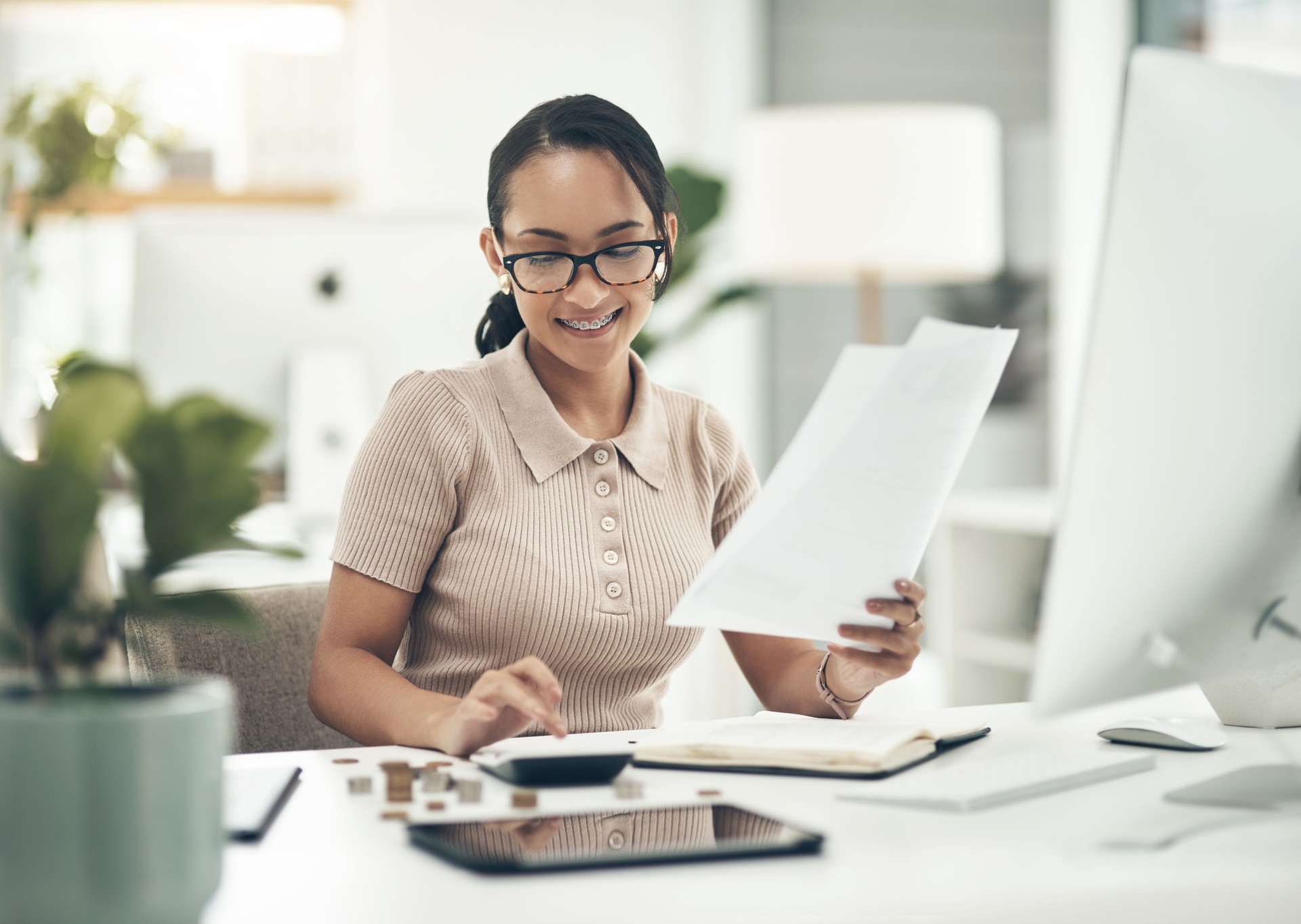 Shot of a young businesswoman calculating finances in an office